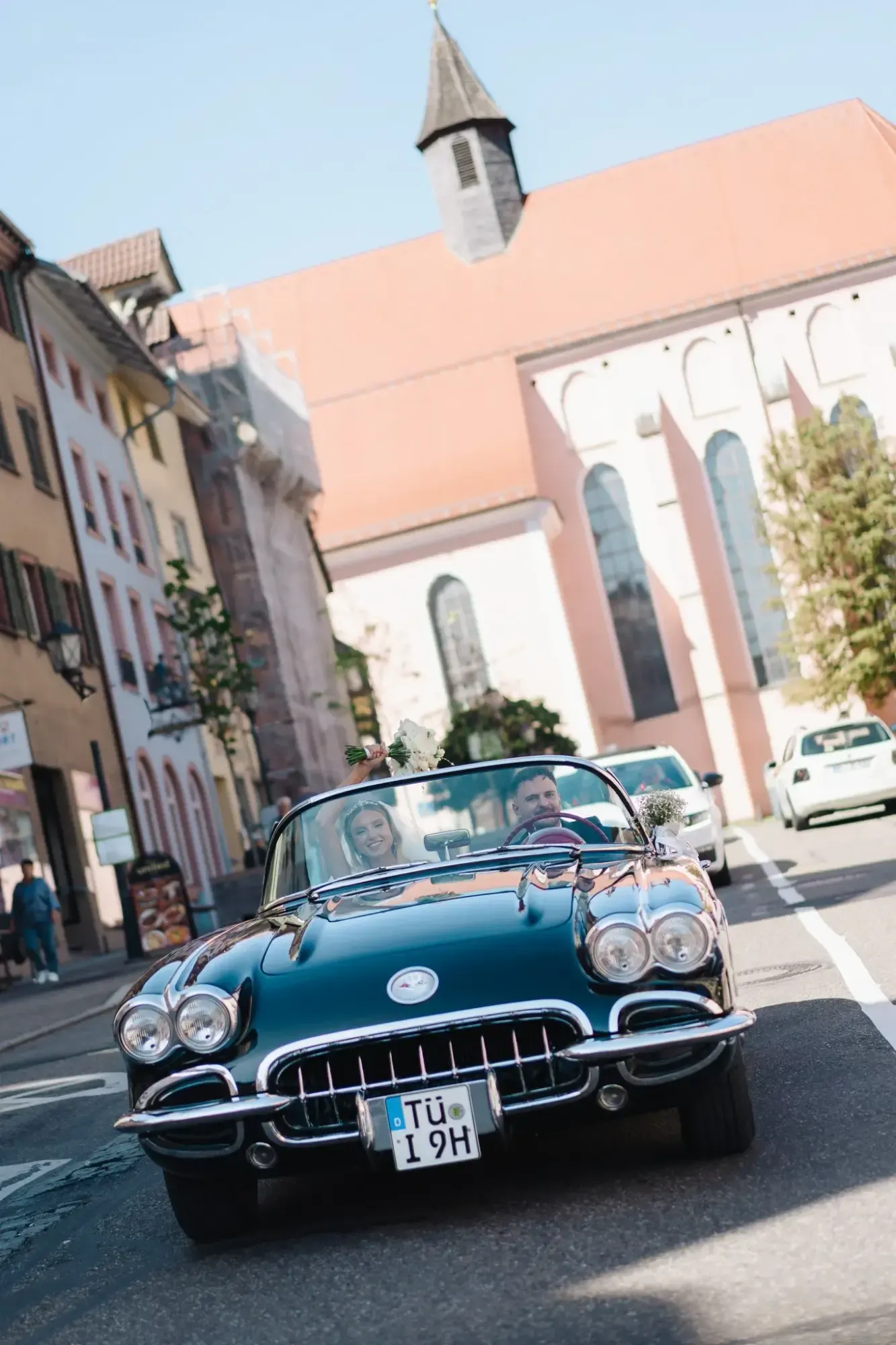 Brautpaar im Oldtimer-Cabrio auf einer Altstadtstraße